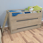 A light oak wood twin loft bed with built-in drawers and a short ladder, styled with blue and green bedding and pillows, set against a gray wall and wood-look floor.